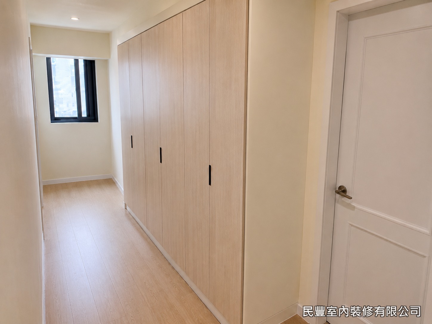民豐室內裝修-臥室衣櫃-系統衣櫃完工呈現木紋質感整牆收納，從地板延伸至天花板充分利用垂直空間，簡約現代的設計與臥室整體風格和諧融合，收納機能大幅提升